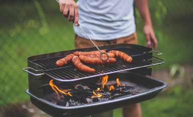 Photo of a man grilling hotdogs